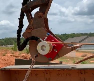 Closeup of excavator bucket with capstan winch attached pulling cable
